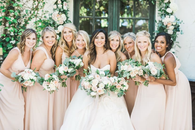 Bride with bridesmaids in blush dresses holding bouquets